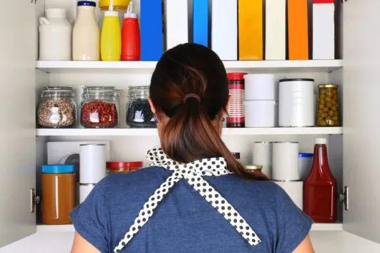 Person looking into a well-stocked pantry