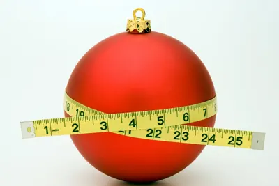 Red holiday ornament wrapped in a measuring tape